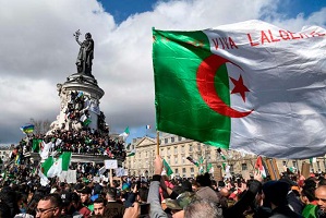 A protester waves and Algerian flag during a rally in support of the ongoing protests in Algeria against the president's bid for a fifth term in power, at Place de la Republique in Paris, on March 10, 2019. / AFP / Bertrand GUAY