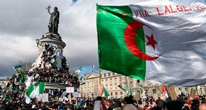 A protester waves and Algerian flag during a rally in support of the ongoing protests in Algeria against the president's bid for a fifth term in power, at Place de la Republique in Paris, on March 10, 2019.  / AFP / Bertrand GUAY